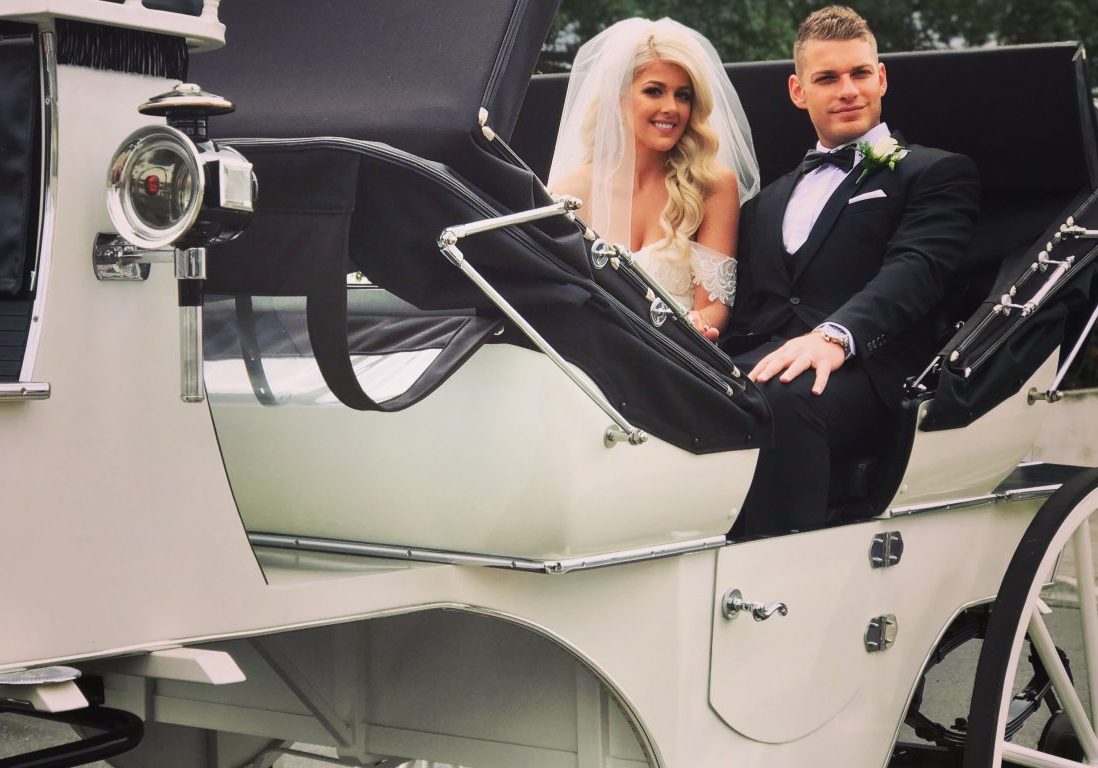 white carriage with black interior and happy couple